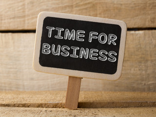 Chalkboard with Time For Business word on wooden background. 