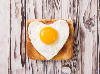 heart shaped cooked egg on a slice of toast