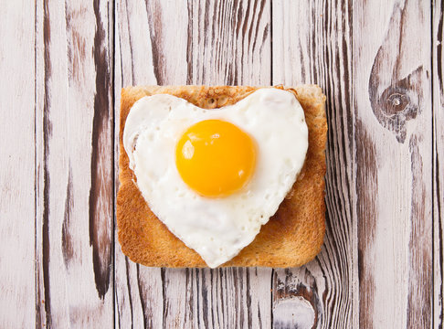 heart shaped cooked egg on a slice of toast