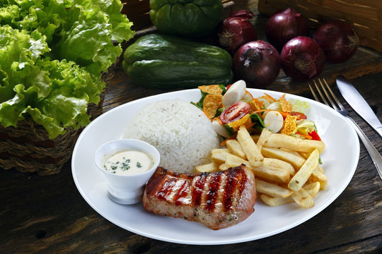 Grilled pork with fries and vegetables
