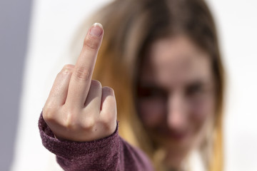 Young woman showing her middle finger up. Rebel youth.