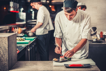 male cooks preparing sushi