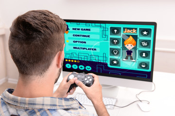Young man playing computer games at home
