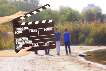 Operator holding clapperboard during the production of film outdoor