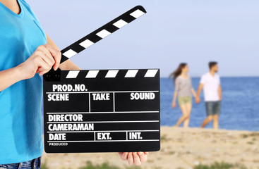 Operator holding clapperboard during the production of film outdoor
