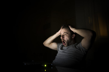 Hombre stresado por una mala noticia trabajando desde su casa por la noche