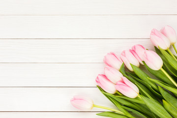 Bouquet of pink tulips on white wooden background. Top view, copy space