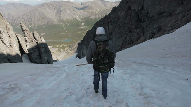 Climbers start to descent from snowy mountain Charrgor pass on slippery slope. Khibiny massif, Kola peninsula, Russia
