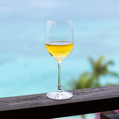 Glass of white wine on balcony rail