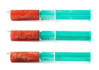 Medical syringe filled with red liquid