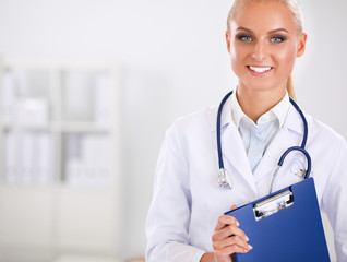 Smiling female doctor with a folder in uniform standing at hospital