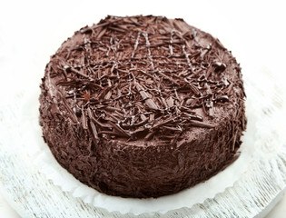 Tasty chocolate cake on wooden table, on light background