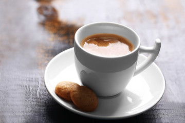 Cup of coffee on wooden table background