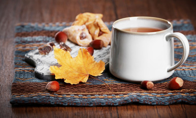 Obraz na płótnie Canvas Cup of tea with autumn decor on wooden table.