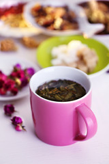 Cup of tea with aromatic dry tea on wooden background