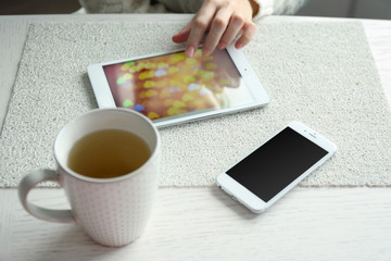 Woman using digital tablet on table close up