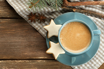 Cup of coffee with star shaped biscuits and Christmas tree branch on napkin