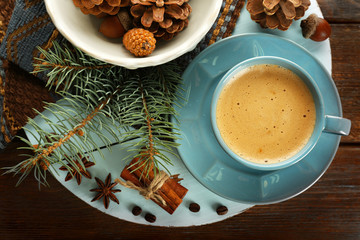 Cup of coffee and Christmas tree branch on wooden mat