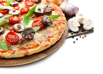 Tasty pizza and fresh vegetables on round wooden board, close up