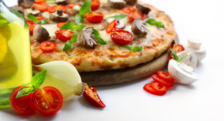 Tasty pizza and fresh vegetables on round wooden board, close up