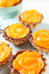 Sweet cakes with tangerines on table, close up