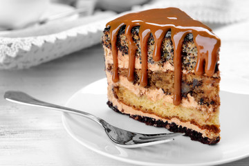 Piece of chocolate cake with caramel on wooden table closeup