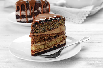 Pieces of chocolate cake with caramel on wooden table closeup