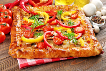 Freshly homemade pizza on wooden table closeup