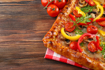 Freshly homemade pizza on wooden background