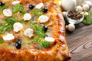 Freshly homemade pizza on wooden table closeup