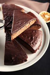 Pieces of frosting chocolate cake on black table