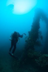 Underwater videographer at work.wreck Nippo Maru in Micronesia. Depth 20 meters.This ship become a home for many fishes and corals since 1942.