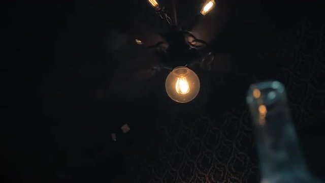 A vintage electric ceiling fan turns slowly in this rather eerie dimly lit room.