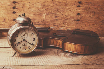 Plakaty  Antyczny zegar i stare skrzypce nad zabytkowym drewnianym stołem