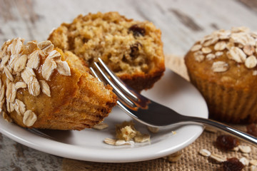 Fresh muffins with oatmeal baked with wholemeal flour on white plate, delicious healthy dessert