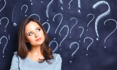 Young girl with question mark on a gray background