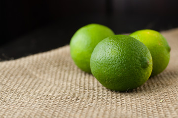 Limes on a beige jute tablecloth