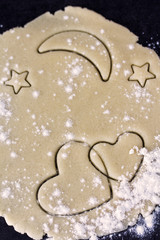 Two crossed hearts on dough layer with moon and stars