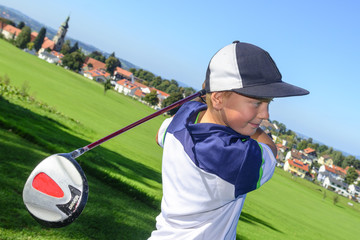 junger Nachwuchsgolfer beim Abschlag