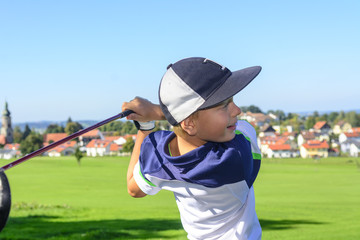 junger Golfer schaut seinem Ball hinterher