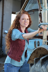 Junge Landfrau am Traktor © absolutimages