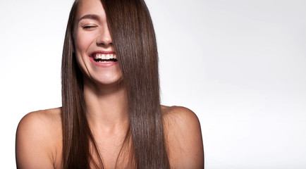 Laughing girl with shiny black hair and perfect clean skin on a white background