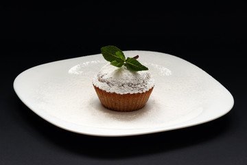 Peppermint cupcake. Sweet cupcake. Close up of mint cupcake. Muffin. Fresh delicious homemade cupcake. Cupcake with mint and frosting on top with powdered sugar. Shallow depth of field.