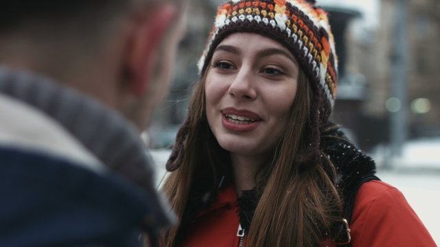 Close-up Of A Girl Talking With Her New Friend And Smiling. Woman Meets A Guy Outdoors And They Have A Sweet Talk. 