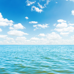 Fototapeta na wymiar low white clouds over blue sea