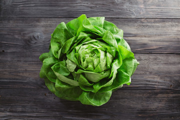 Single lettuce head over rustic wooden background