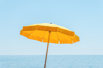 yellow umbrella near sea under blue sky