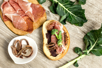 bruschetta with olive paste, parma ham, broccoli and anchovy