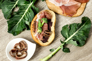 bruschetta with olive paste, parma ham, broccoli and anchovy