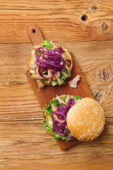 Burger with meat of duck with red onion and lettuce.